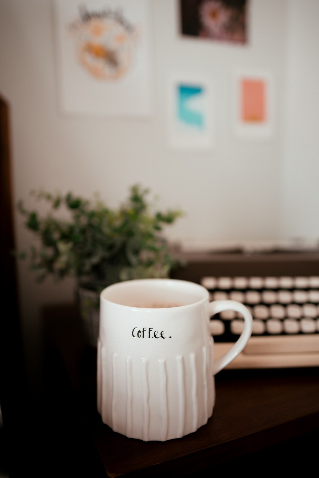 White mug of coffee labelled 'coffee' on a wooden table